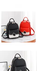 Detail of black and red leather backpacks with white quilted pockets and daisy charms