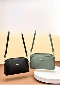 Close-up of quilted faux leather crossbody bags in black and green with double zippers