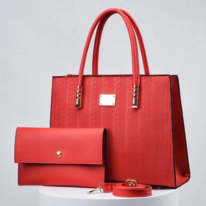 Red woven leather tote bag and pouch set with gold hardware on a display stand