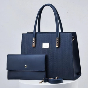 Detail of navy blue textured tote bag set with golden hardware and matching pouch