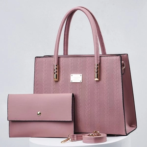 Close-up of rose pink tote bag with woven texture, matching wallet and gold hardware