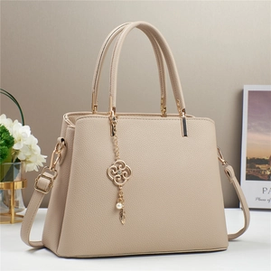Elegante borsa a mano beige testurizzata con catena floreale dorata e tracolla regolabile