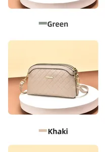 Detail of khaki quilted crossbody bag with three zipper compartments and gold hardware