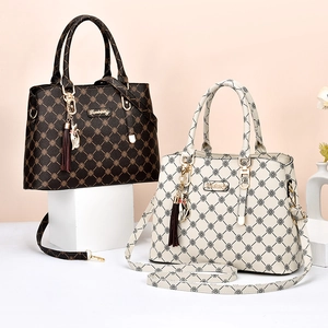 Sac bandoulière rétro monogramme avec pompon et pendentif chat doré élégant