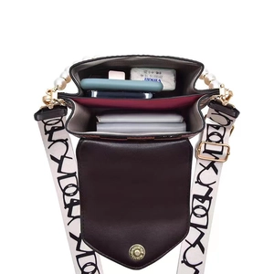 Chic checkered handbag with pearl handle and wide lettered strap showing inner compartments