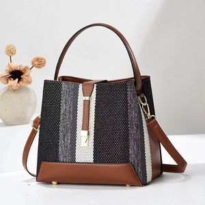 Détail du sac seau rayé tricolore avec ferrures dorées et garnitures en cuir