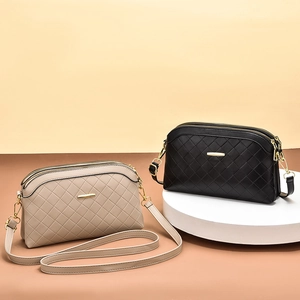 Quilted faux leather crossbody bag with dual zipper compartments and gold metal details