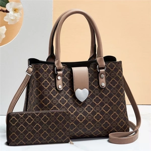Set borsa tote marrone con fibbia a cuore e portafoglio coordinato su sfondo elegante