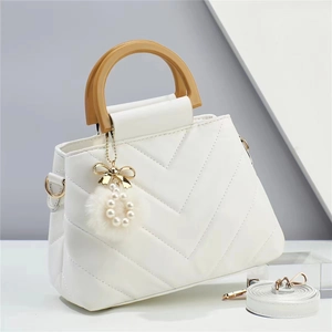 White V-quilted handbag with wooden handles, pearl pom-pom charm and adjustable strap