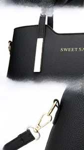Détails du sac à main en cuir grainé noir avec fermeture éclair et crochets dorés brillants