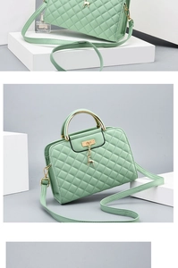Detail of mint green quilted leather bag with golden deer charm and metal handle