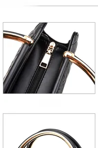 Black quilted crossbody bag featuring curved gold metal handle and smooth zipper detail