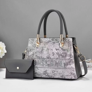 Detail of grey floral patterned tote bag with detachable strap and matching pouch set
