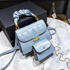 Close-up of light blue quilted handbag set with cloud handle and gold triangle buckle