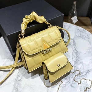 Detail view of ginger yellow quilted handbag set with cloud handle and chain bag