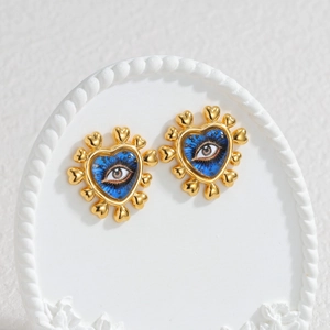 18k gold heart-shaped stud earrings with blue evil eye motif on elegant display