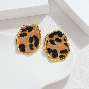 Irregular leopard print earrings with 18k gold plating on minimalist white stone background