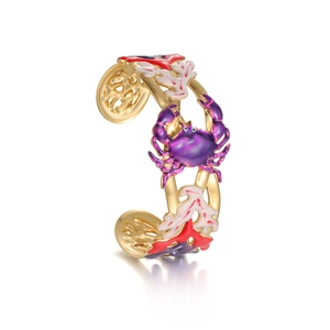 Golden sea-themed cuff bracelet with purple enamel crab and red coral motifs