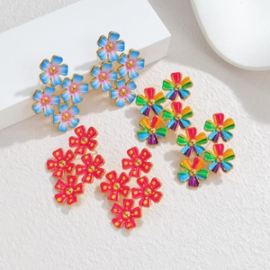 Détail de boucles d'oreilles fleurs en émail bleu, arc-en-ciel et rose avec doré 18k
