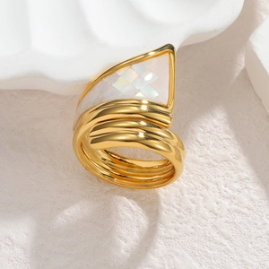 Dettaglio dell'anello dorato irregolare con inserto in madreperla bianca a forma triangolare
