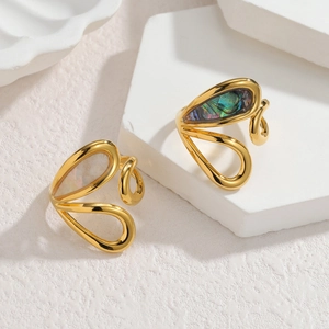Anelli in oro 18k con inserti in madreperla e abalone su espositore in gesso moderno