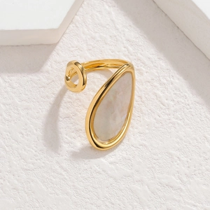 Dettaglio macro di intarsio in conchiglia a goccia su un anello dorato aperto regolabile
