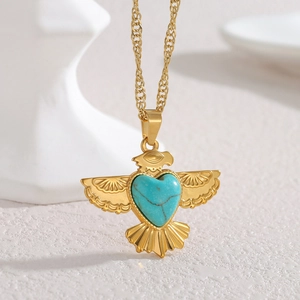 Collier aigle doré bohème avec pendentif turquoise en cœur sur support blanc minimaliste