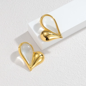 Asymmetric 18K gold heart earrings with white cat-eye stone on a geometric stand