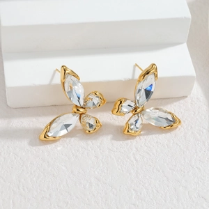 Élégantes boucles d'oreilles papillon plaquées or 18 carats avec zircons sur socle blanc