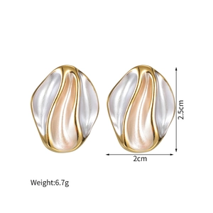 Detail view of irregular 18k gold plated wave earrings with white pearlescent inlay