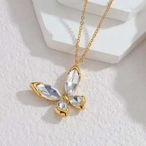 Detail of a 18k gold butterfly pendant necklace with inlaid clear marquise crystal stones
