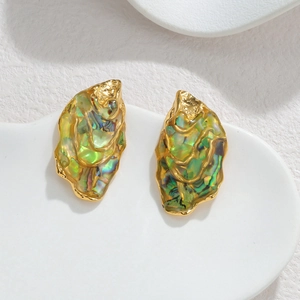 Irregular 18k gold plated abalone shell earrings on a minimalist ceramic dish