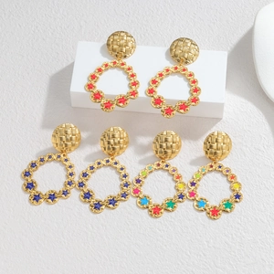 Detail of 18k gold geometric hoop earrings with colorful enamel star patterns