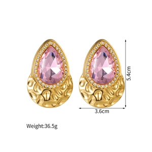Detailed view of pink teardrop earrings with gold textured base and white crystals