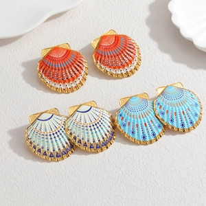 Detailed macro view of colorful ocean-style shell earrings with 18k gold edges