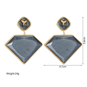 Dettaglio di orecchini geometrici in oro 18k con resina blu-grigia e altezza di 5,8 cm