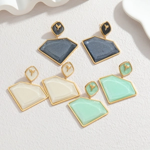 Dettaglio orecchini geometrici placcati oro 18k con resina nera crema e verde menta