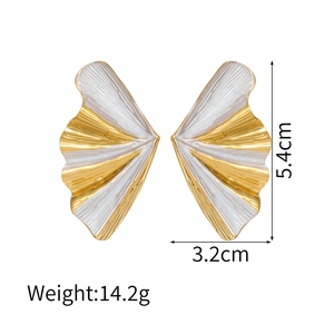 Detailed view of fan-shaped 18k gold earrings with white enamel and pleated texture