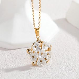 18k gold necklace with a floral pendant featuring white enamel petals and small crystals