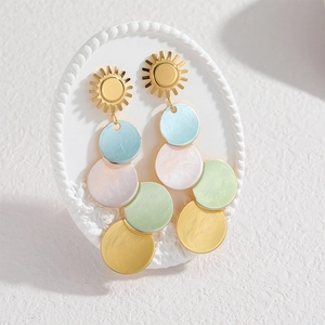 Colorful macaron circular drop earrings with gold sun stud on elegant white relief display