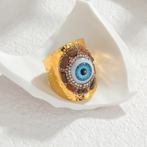 Bague large Evil Eye dorée avec texture martelée et pierres précieuses style bohème