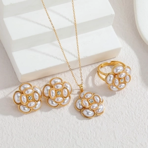 Vue rapprochée d'un ensemble de bijoux fleur en perles et or 18 carats avec collier