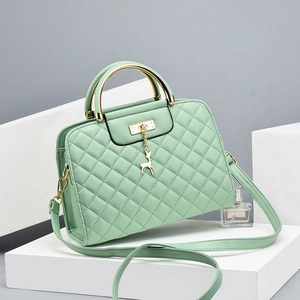 Mint green quilted crossbody bag with gold deer charm and metallic handle detail