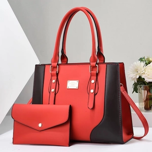 Detail von rot-schwarzem Shopper-Set mit strukturiertem Kunstleder und Goldbeschlägen