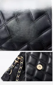 Detail of black quilted leather shoulder bag with gold chain strap and magnetic closure
