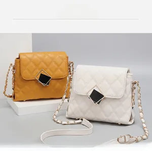 Detail of quilted leather texture and two-tone turn-lock on crossbody chain bags