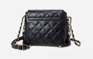 Detail of black quilted leather shoulder bag with gold chain strap and bottom metal feet