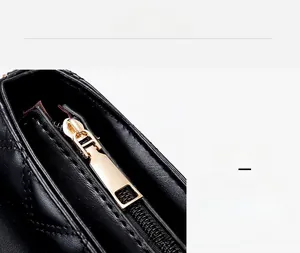 Detailed view of the premium golden metal zipper on a black quilted chain handbag