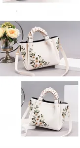 Detail of floral embroidery on cream white Boston bag with braided handle and logo