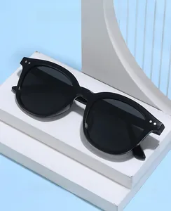 Detail showing classic black round frame sunglasses with UV protection and rice nail accents